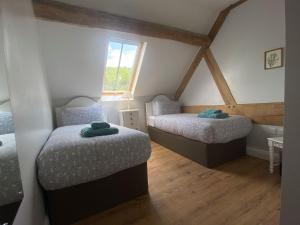 a bedroom with two beds in a attic at The Buttery - RFFO in Fownhope