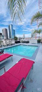 a swimming pool with chairs and a red blanket at Huge Downtown LA Loft with Rooftop Pool & Jacuzzi in Los Angeles