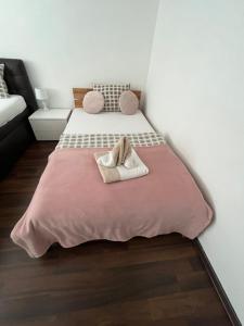 a bedroom with two beds with a pink blanket at Apartments Nifia in Liptovský Ján