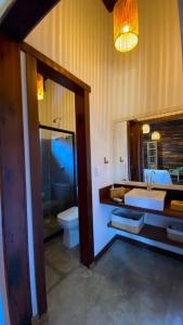 a bathroom with a sink and a toilet and a mirror at Akua Bungalows in Marau