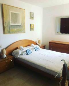a bedroom with a bed with blue and white pillows at Joli appartement centre avec terrasse vue mer in Tossa de Mar