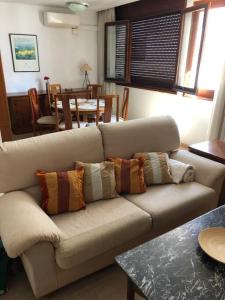a living room with a couch with pillows on it at Joli appartement centre avec terrasse vue mer in Tossa de Mar