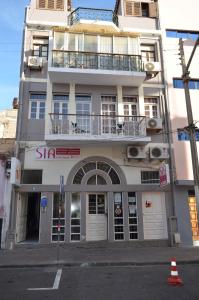 a tall white building with a balcony on it at Plateau Apartment in Praia