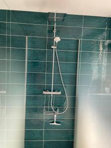 y baño con ducha y azulejos verdes. en Magnifique appartement climatisé de 87m², à 100m de la plage, en Antibes