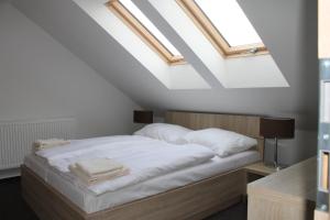 Sečovce的住宿－Penzion Bowten，一间卧室配有一张带白色床单和天窗的床。