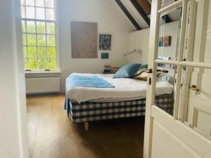 Habitación pequeña con cama y ventana en Heerlijke boerderij bij Veluwezoom in het Oude Dieren en Dieren