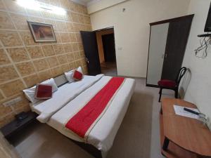 a bedroom with a large bed with a red and white blanket at Hotel Shiv Angan in Jaipur