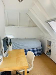 um quarto com uma secretária e uma cama num sótão em Heerlijke boerderij bij Veluwezoom in het Oude Dieren em Dieren