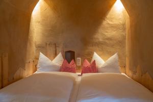 a bedroom with a large white bed with red pillows at Turm zu Schloss Schedling in Trostberg an der Alz