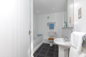 a white bathroom with a sink and a toilet at 15 Boscaswell Downs in Penzance +20 photos