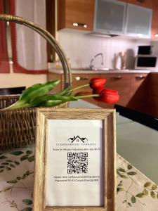 um sinal numa mesa com tulipas vermelhas numa cozinha em La Mansarda del Viandante em Castelbelforte