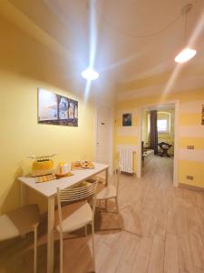 una sala da pranzo con pareti gialle e tavolo e sedie di Tecla House a La Spezia