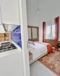 a bedroom with a bed and a kitchen with a stove at Casa Maddy Anacapri in Anacapri