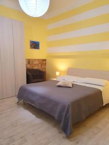 een slaapkamer met een bed en een gele muur bij Tecla House in La Spezia