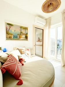 a white bedroom with a large bed with pillows at Casa Maddy Anacapri in Anacapri