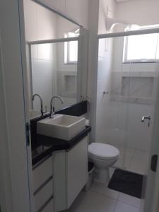 W łazience znajduje się umywalka, toaleta i prysznic. w obiekcie Apartamento Praia do Santinho w mieście Florianópolis