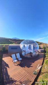 una casa en una cúpula de cristal sentada en una terraza de madera en Hotel burbuja Finca Esferas, en Santa Cruz de Tenerife