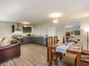 a living room and kitchen with a table and a couch at Ffynnon Bach in Caernarfon
