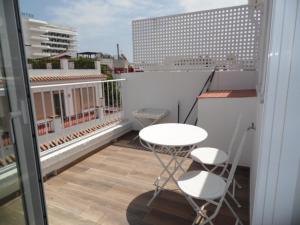 d'un balcon avec une table blanche et deux chaises. dans l'établissement Apartamentos San Miguel, à Torremolinos