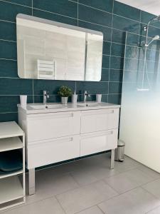 y baño con lavabo blanco y espejo. en Magnifique appartement climatisé de 87m², à 100m de la plage, en Antibes