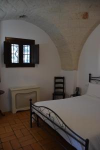 a bedroom with a bed and a window at Borgo Santuri in Ostuni