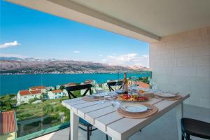 a dining table with a view of the water at Apartvilla Pag in Pag