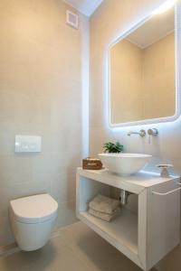 a bathroom with a sink and a toilet and a mirror at Apartvilla Pag in Pag