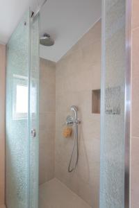 baño con ducha y puerta de cristal en Apartvilla Pag, en Pag