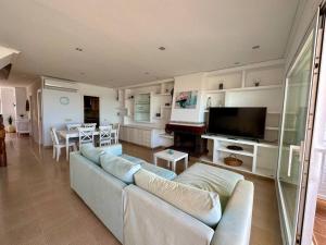 sala de estar con sofá y TV en Breathtaking Beachfront House, en Sueca