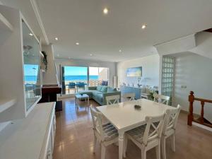 uma sala de jantar e sala de estar com mesa e cadeiras em Breathtaking Beachfront House em Sueca