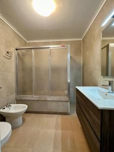 uma casa de banho com um chuveiro, um WC e um lavatório. em Breathtaking Beachfront House em Sueca