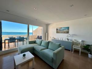 uma sala de estar com um sofá e vista para o oceano em Breathtaking Beachfront House em Sueca