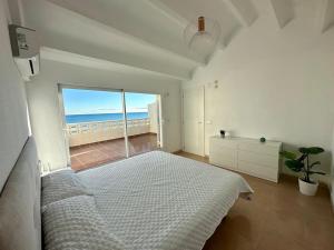 a bedroom with a bed and a view of the ocean at Breathtaking Beachfront House in Sueca