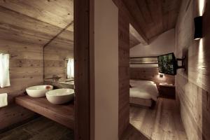 ein Bad mit 2 Waschbecken und ein Bett in einem Zimmer in der Unterkunft Chesa Stuva Colani in Madulain