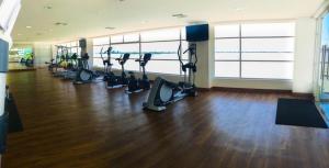 un gimnasio con cintas de correr y elípticas en un edificio en Departamento Real Suite, en Guayaquil