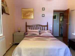 a bedroom with a large bed with pink walls at Los Robles in Ávila