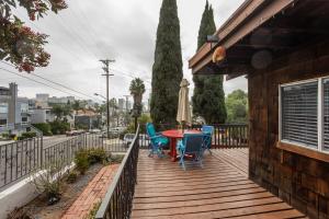 a wooden deck with a table and chairs and an umbrella at COZY Studio in Downtown San Diego in San Diego