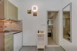 a kitchen with white cabinets and a mirror at Split centar Aria apartment in Split