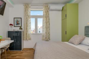 a bedroom with a bed and a desk and a window at Split centar Aria apartment in Split