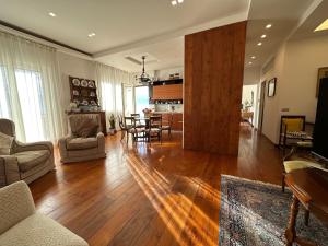 a living room with wooden floors and a dining room at Appartamento Mira Capri in Torre Annunziata