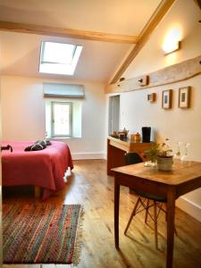 1 dormitorio con cama, mesa y ventana en Belle et spacieuse chambre d’hôtes avec piscine, en Savignac-de-Duras