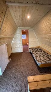 PerštejnにあるCHATA VÁCLAV ÚDOLÍČKOの木造キャビン内のベッド1台が備わる小さな客室です。
