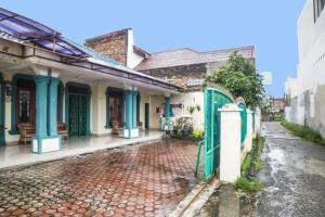 ein altes Haus mit grünem Tor in einer Straße in der Unterkunft OYO 92075 Sky Residence Mawar in Sunggal
