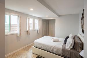 a bedroom with a bed and two windows at Spacious Guest Suite Amazing Location in San Diego