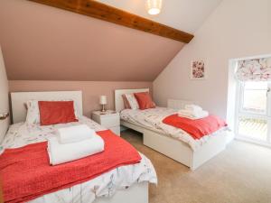 a bedroom with two beds and a window at Hope House Stables in Tiverton