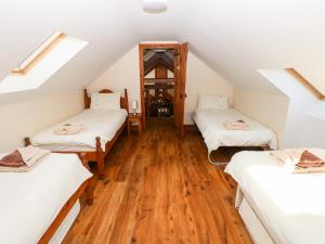 Zimmer im Dachgeschoss mit 2 Betten und Holzböden in der Unterkunft The Mill and Stable in Llansadurnen