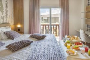 Una habitación de hotel con una cama con una bandeja de comida. en Hotel Estoril en Campos do Jordão