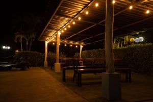 un patio con bancos y luces por la noche en Hotel El Rancho, en Quepos
