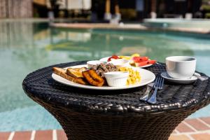 un plato de comida en una mesa junto a una piscina en Hotel El Rancho, en Quepos
