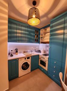 cocina con armarios azules y lavadora en Apartment Bety, Stomorska, Solta, en Stomorska